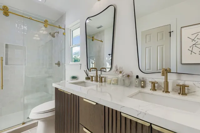 a bathroom with a double vanity sink mirror double and a toilet