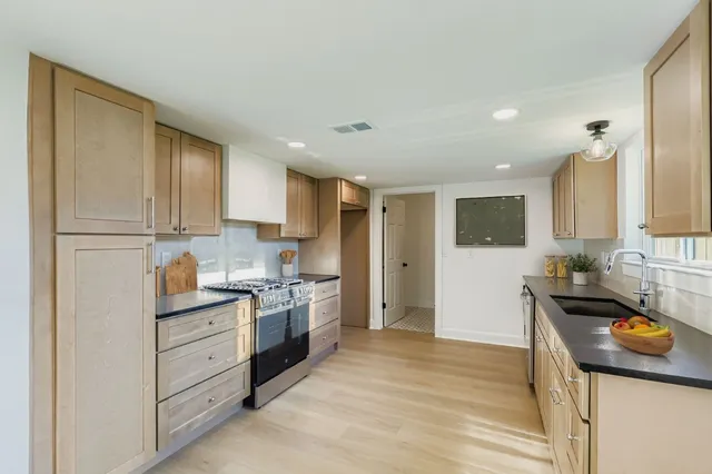 a kitchen with a sink stove and cabinets