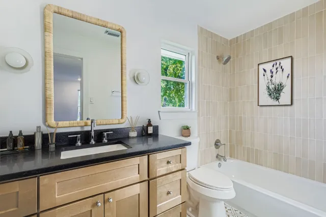 a bathroom with a granite countertop sink toilet and shower