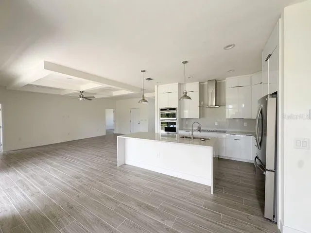 a kitchen with stainless steel appliances a refrigerator and wooden floor