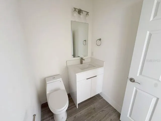 a bathroom with a toilet sink and mirror