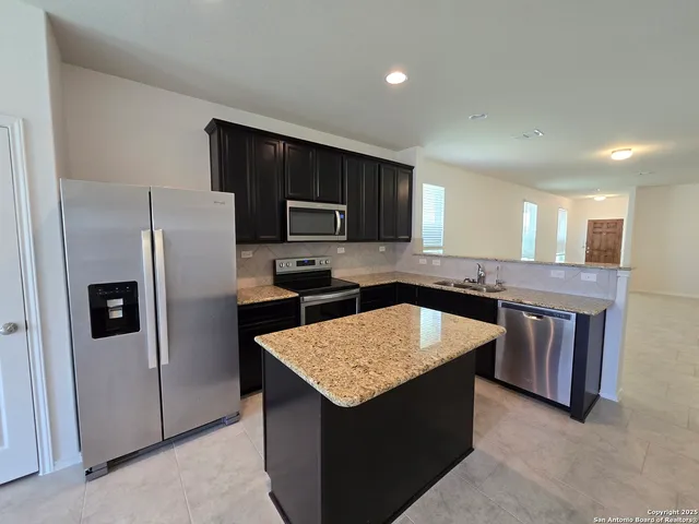 a kitchen with a refrigerator a sink and a stove