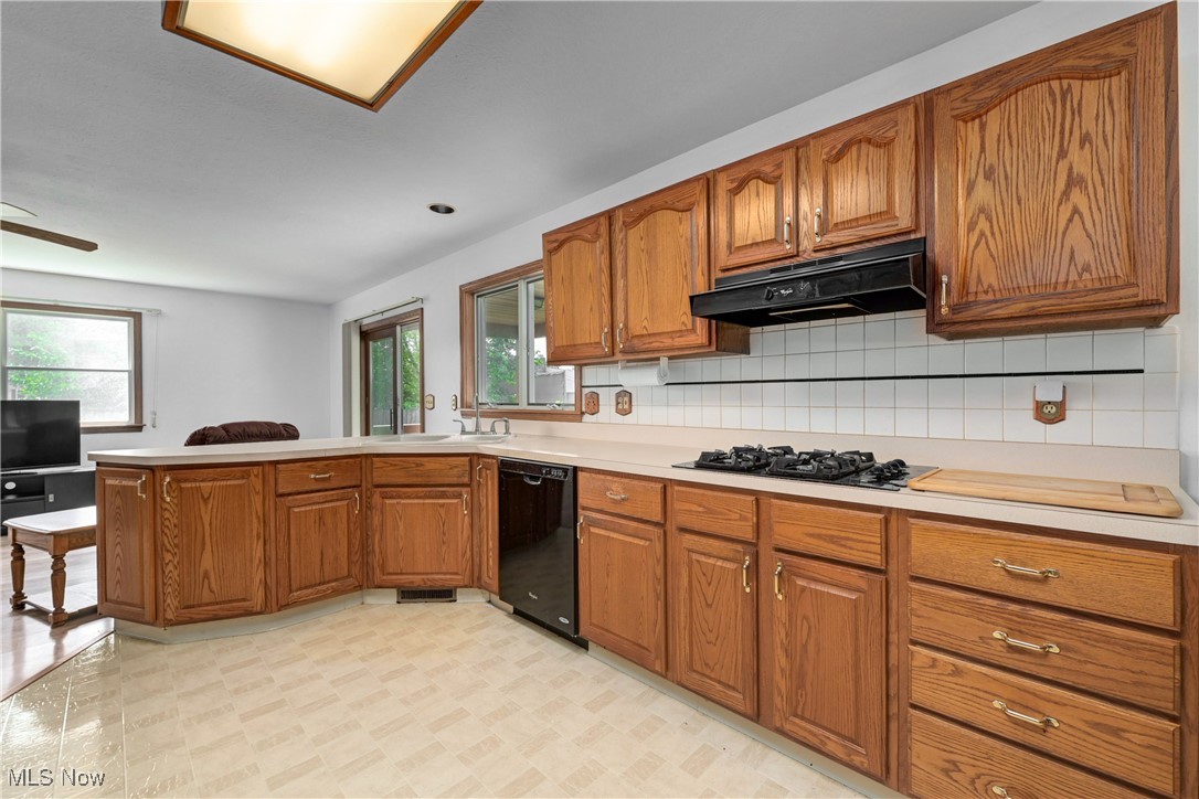 1140 West River Road Vermilion, OH 44089 - Photo 10 of 49 Kitchen featuring brown cabinets, light countertops, backsplash, and a peninsula