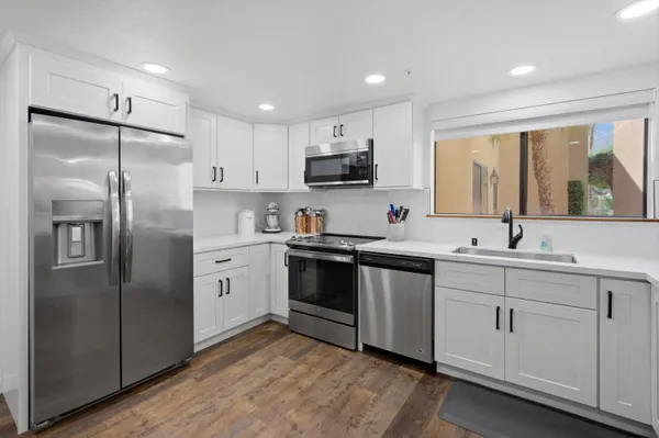 a kitchen with stainless steel appliances cabinets a sink and a window