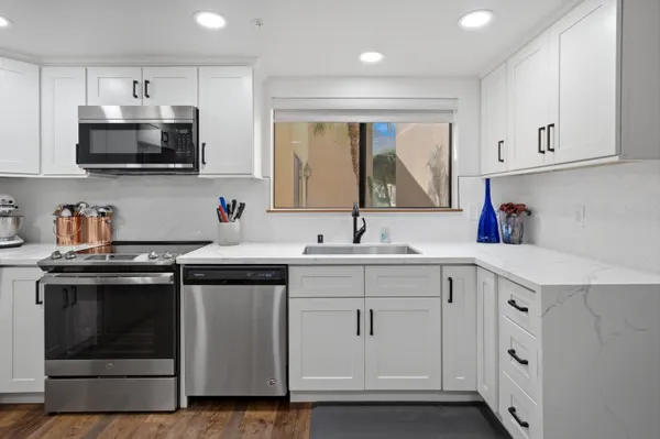 a kitchen with stainless steel appliances granite countertop a sink and a stove