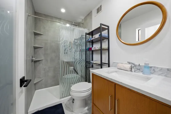 a bathroom with a sink a toilet and a mirror