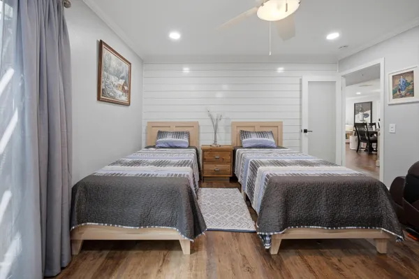 a bedroom with two beds and painting on the wall