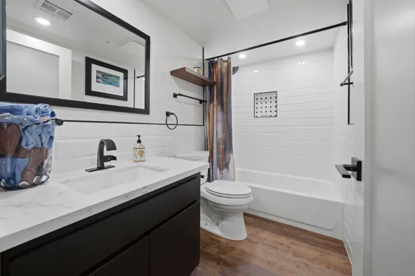 a bathroom with a granite countertop sink toilet and shower