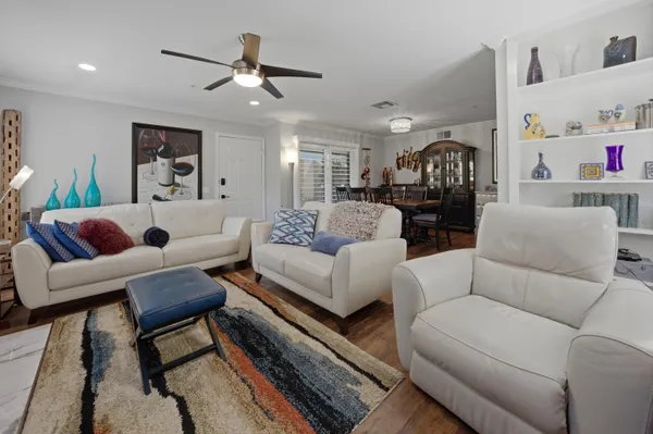 a living room with furniture and a ceiling fan