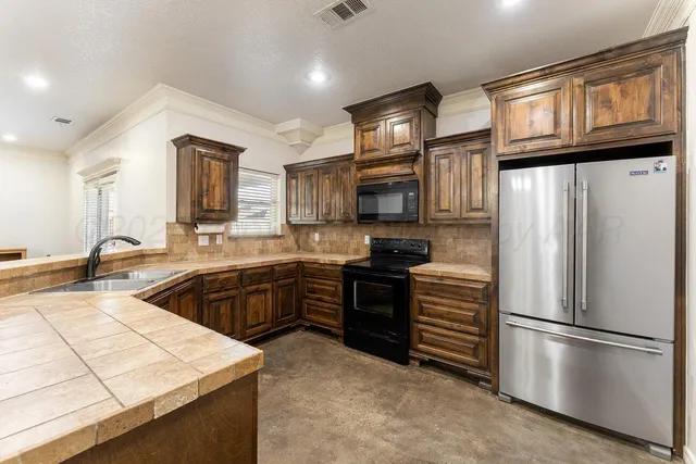 a kitchen with stainless steel appliances granite countertop a refrigerator stove microwave and sink