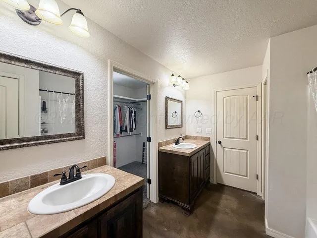 a en suite bathroom with a granite countertop sink and a mirror