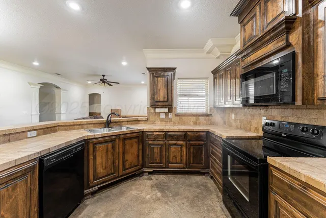 a kitchen with stainless steel appliances granite countertop a sink and stove top oven