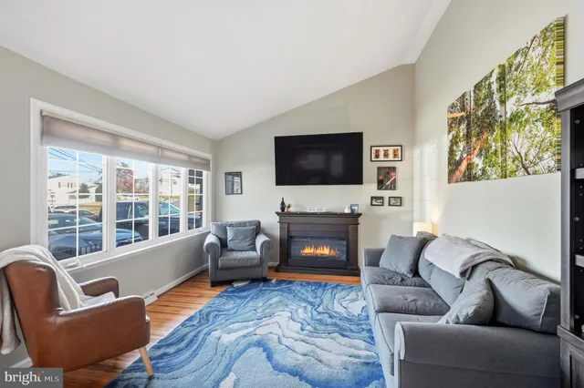 a living room with furniture a fireplace and a flat screen tv