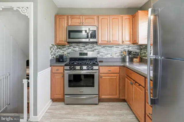 a kitchen with stainless steel appliances granite countertop a stove a microwave and a refrigerator