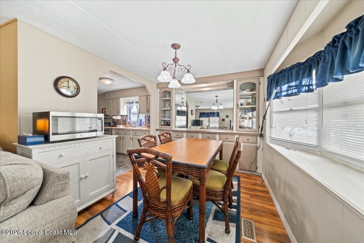 1740 Seagrape Street Northeast Palm Bay, FL 32905 - Photo 6 of 33 a kitchen with a table chairs and a refrigerator