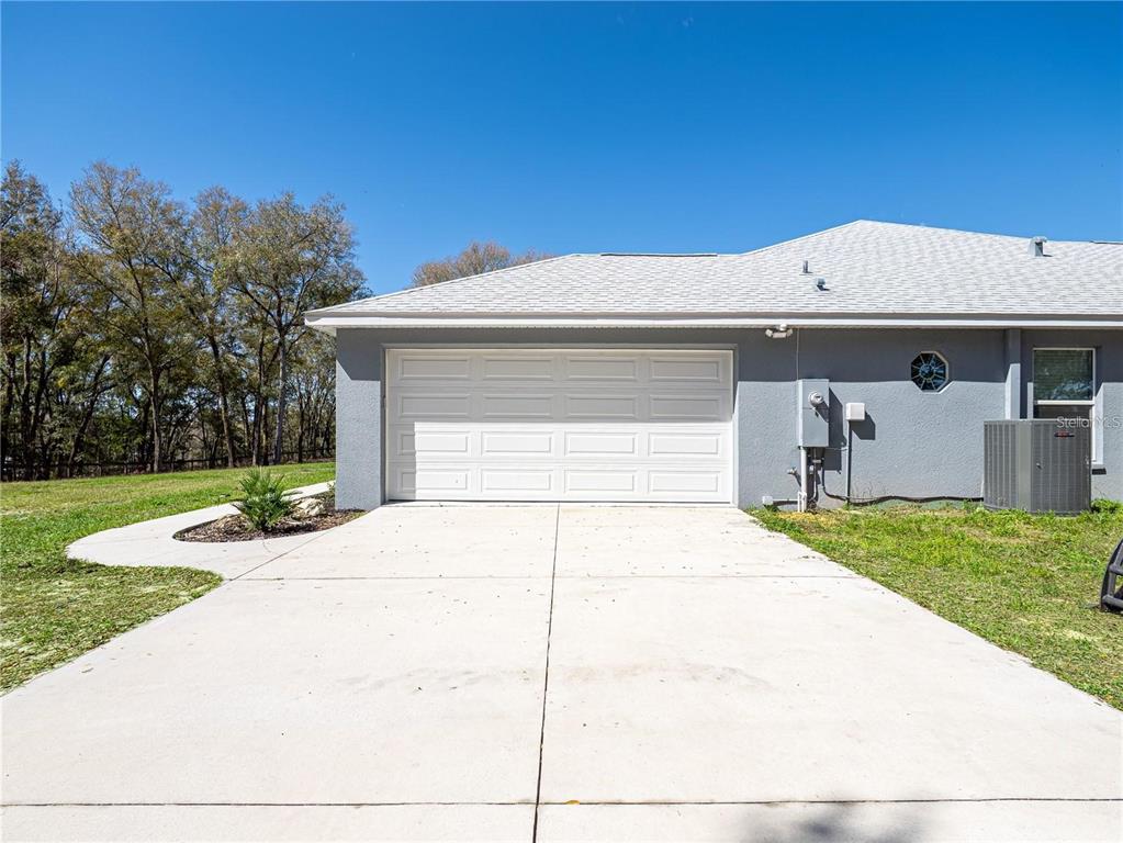 10688 Southwest 129th Terrace Road Dunnellon, FL 34432 - Photo 3 of 35 a front view of a house with a yard and garage
