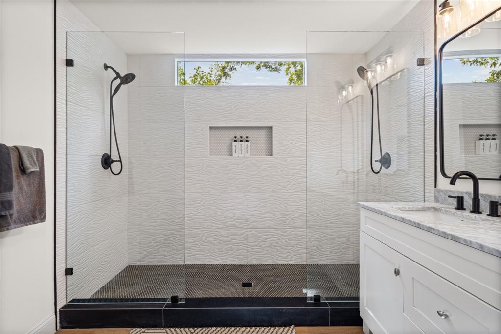 1201 Garden Street, Unit A Austin, TX 78702 - Photo 16 of 30 Walk-in shower featuring textured white tile, dual black shower systems, and glass enclosures