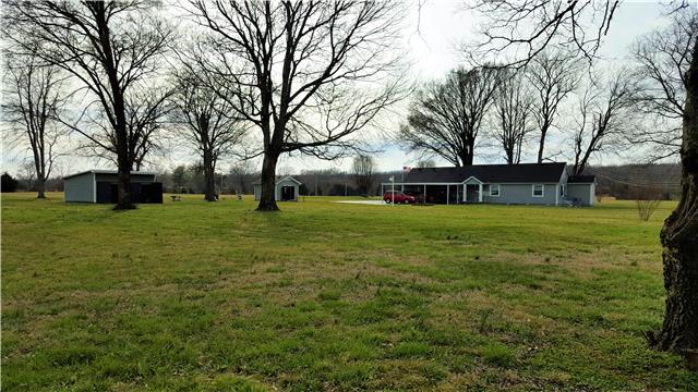 View of home, 2 sheds and property.  Mature trees and garden space. Bring your horse, goat, chickens.2 car carport with 2 additional spaces on black top drive.