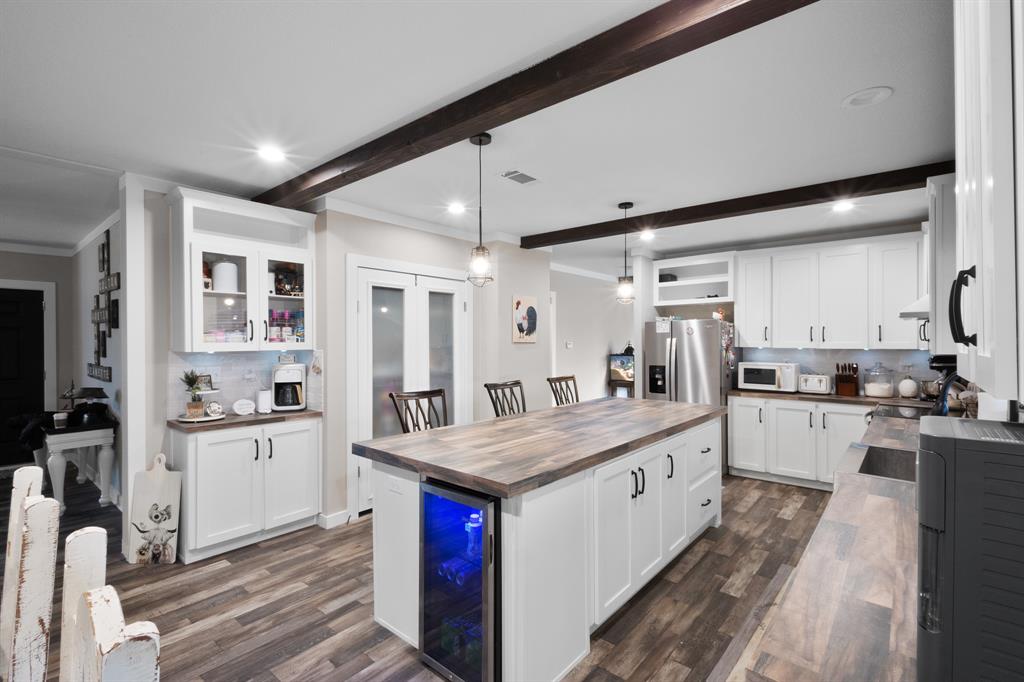 a large white kitchen with a large window a sink and stainless steel appliances