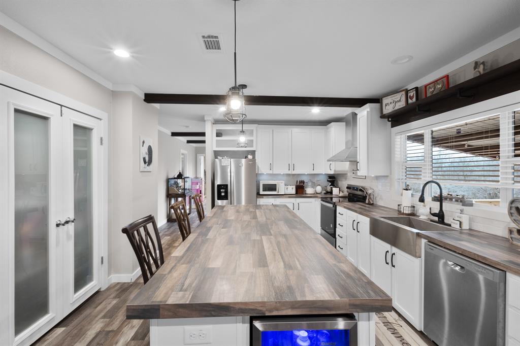 1012 County Road 1180 Decatur, TX 76234 - Photo 5 of 34 a kitchen with granite countertop a sink a counter space appliances and cabinets