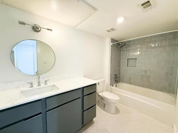 a bathroom with a double vanity sink toilet mirror and shower