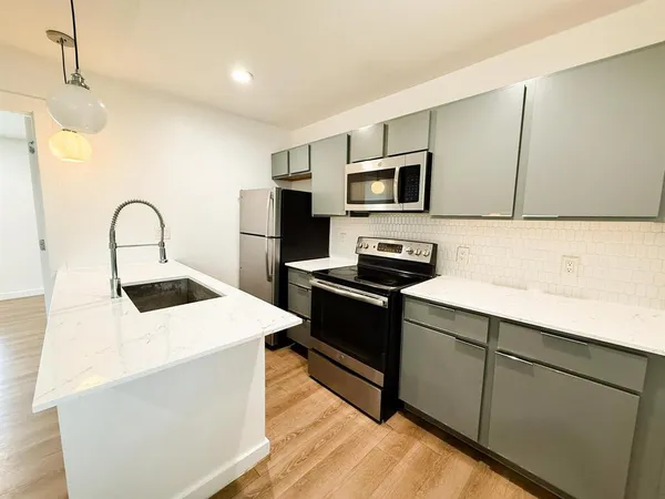 a kitchen with kitchen island a sink appliances and cabinets