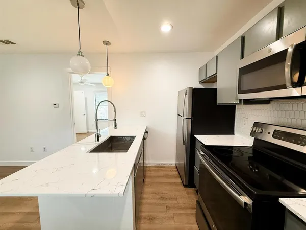 a kitchen with a sink and stainless steel appliances