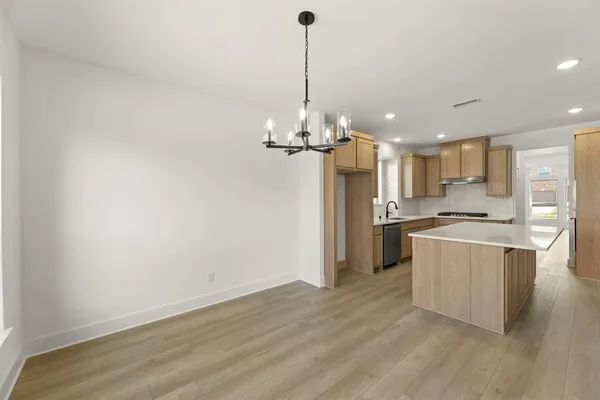 a kitchen with kitchen island stainless steel appliances a refrigerator sink and cabinets