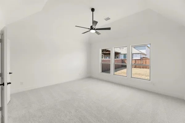 an empty room with windows and ceiling fan