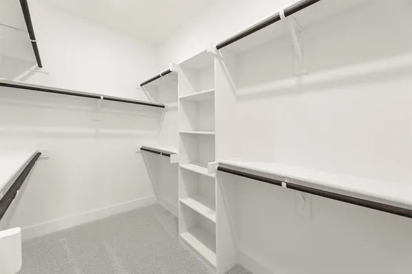 a view of walk in closet with empty racks