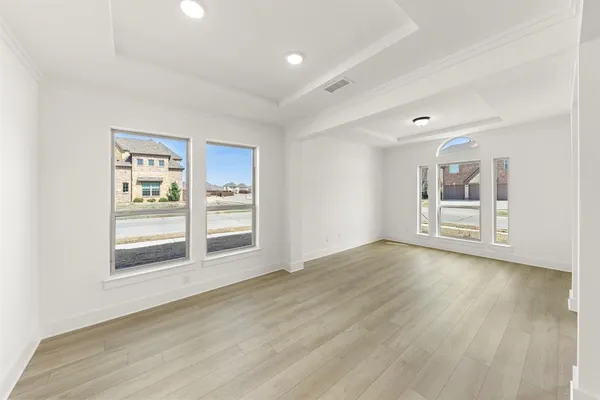 a view of an empty room with a window and wooden floor