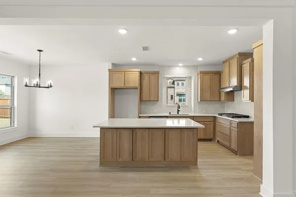 a large kitchen with stainless steel appliances granite countertop a stove a sink and a refrigerator
