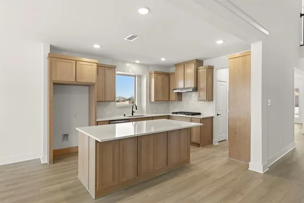 a large kitchen with stainless steel appliances granite countertop a sink stove and refrigerator