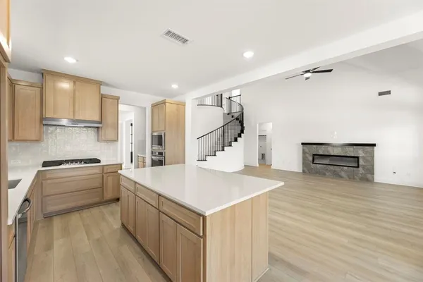 a kitchen with a refrigerator a stove and a wooden floor