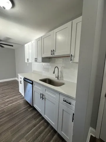 a kitchen with sink a microwave and cabinets