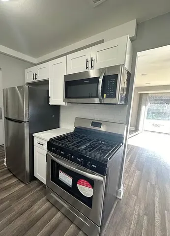 a kitchen with stainless steel appliances a stove a microwave and a refrigerator