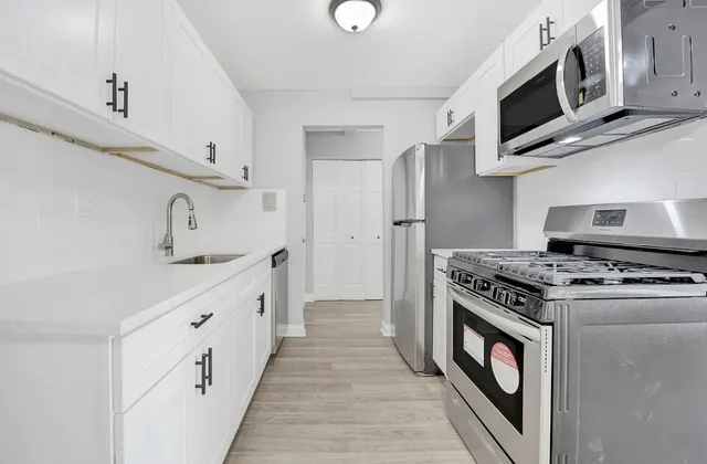 a kitchen with stainless steel appliances a stove microwave and sink