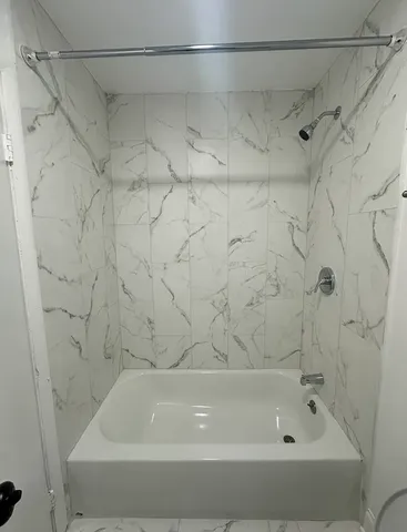 a bathroom with a bathtub and a shower