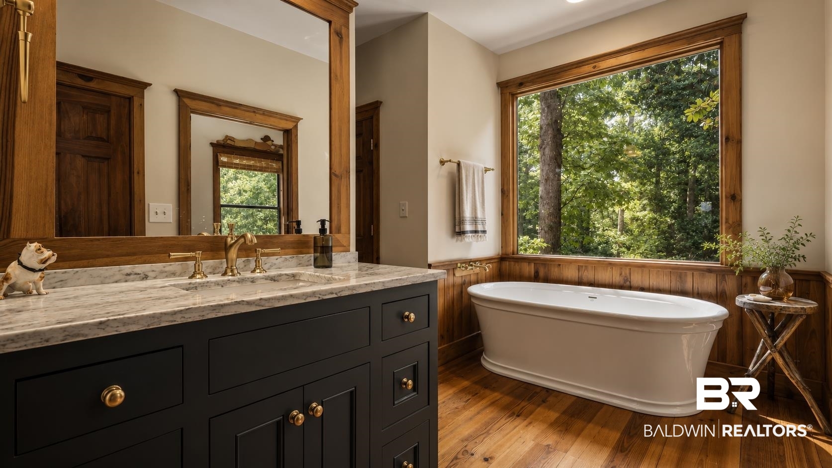 14587 Ridge Road Summerdale, AL 36580 - Photo 22 of 44 Freestanding soaking tub with a large picture window, wood-finish flooring, a dark-toned vanity with gold-toned hardware, and a light-toned countertop