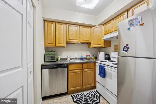 a kitchen with a sink a refrigerator and cabinets
