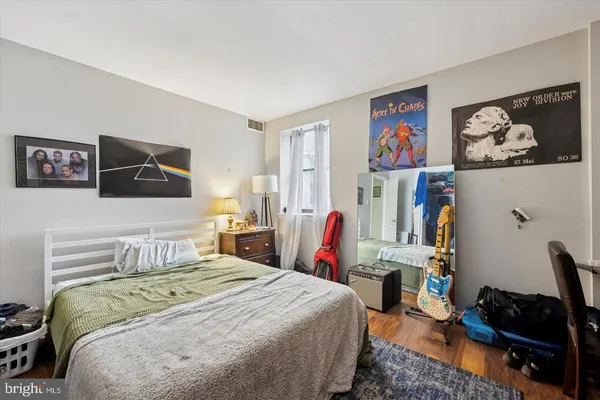 a bedroom with a bed and wooden floor