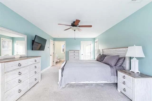 a bedroom with a large bed and a flat tv screen on dresser