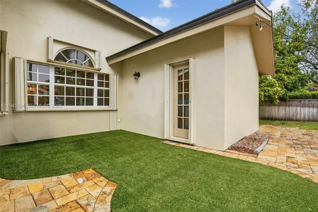 a front view of a house with a yard and potted plants