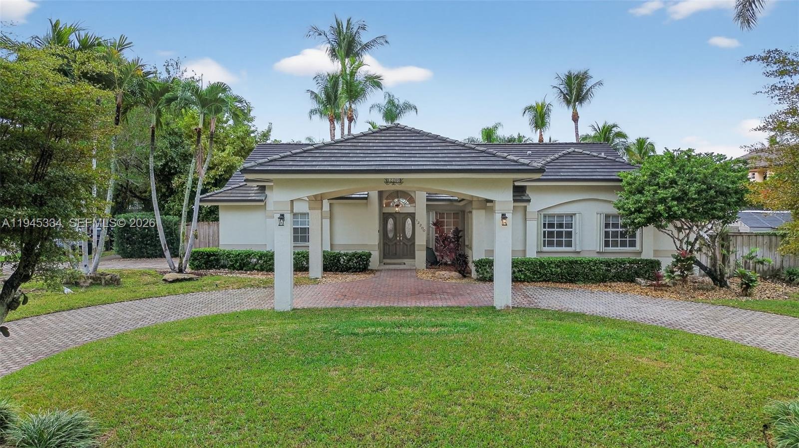 12200 Southwest 100th Street Miami, FL 33186 - Photo 42 of 48 a front view of a house with a yard and potted plants