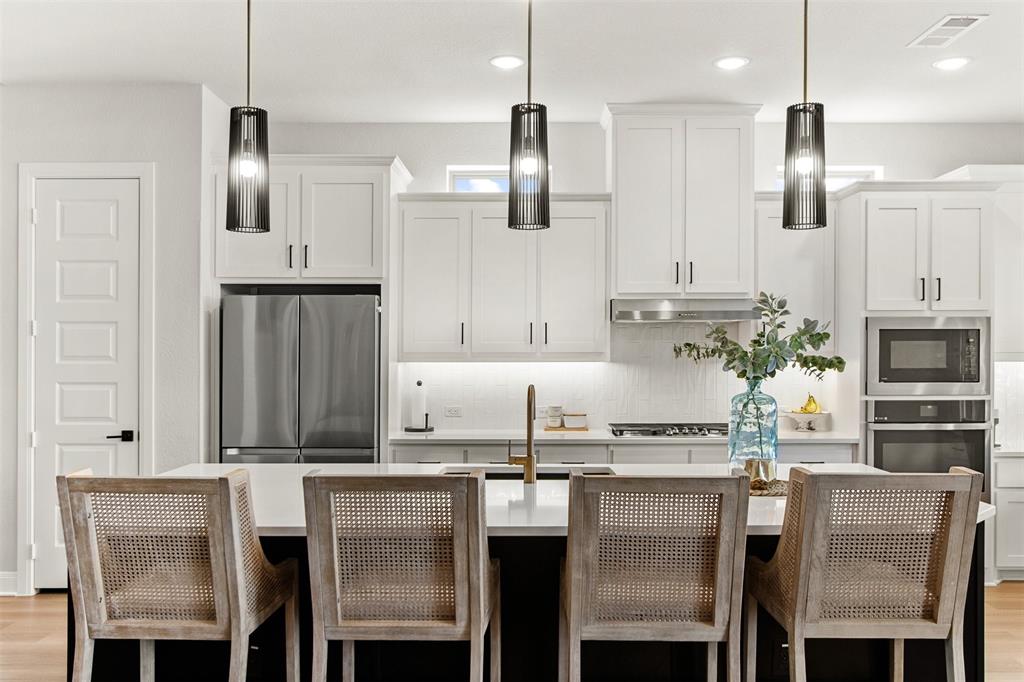 2708 Darlington Road Northlake, TX 76226 - Photo 12 of 40 a kitchen with kitchen island granite countertop a table chairs microwave and cabinets