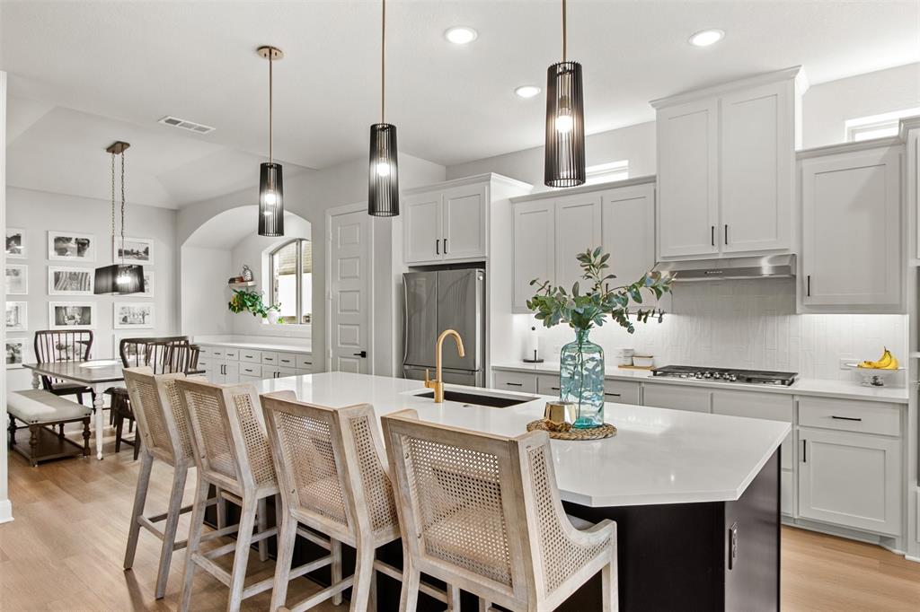 2708 Darlington Road Northlake, TX 76226 - Photo 16 of 40 a kitchen with stainless steel appliances kitchen island granite countertop a dining table chairs and white cabinets