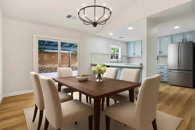 a view of a dining room with furniture a chandelier and wooden floor
