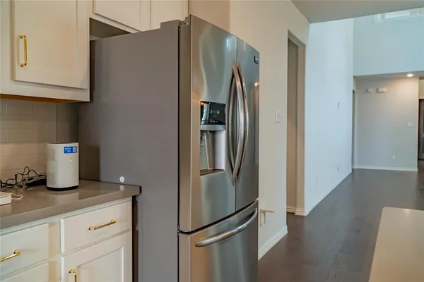 a kitchen with stainless steel appliances a refrigerator and a hard wood floor