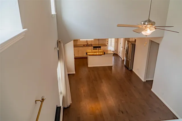 a view of a room with wooden floor and ceiling fan