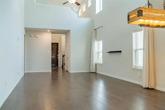 a view of a hallway with wooden floor and a chandelier